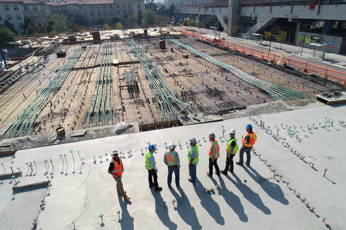Site engineers in hard hats standing on a reinforced concrete deck